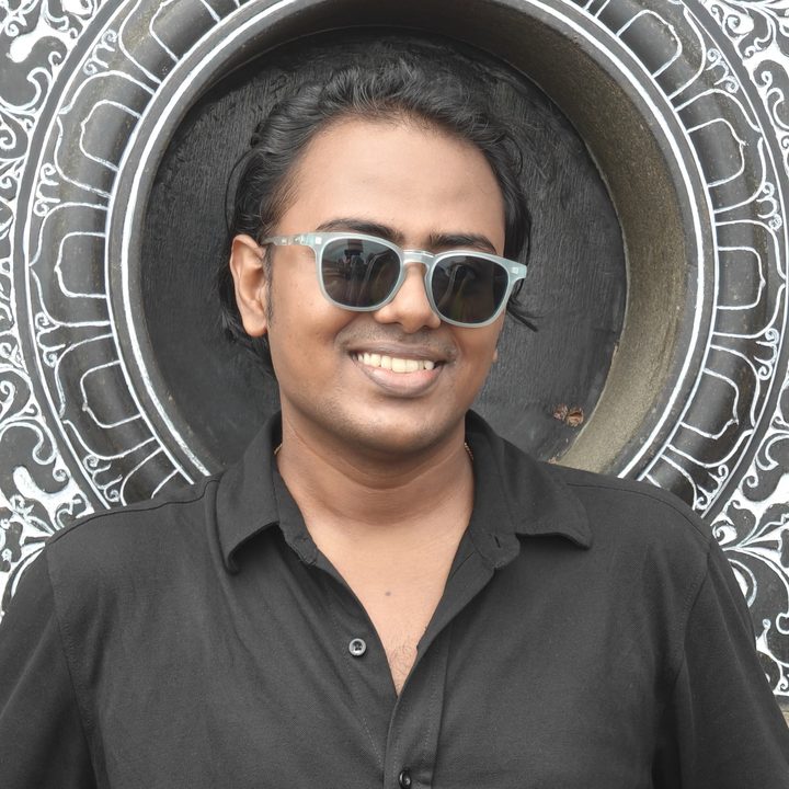 Narendra Krishna Ram, smiling, in sunglasses and a black shirt